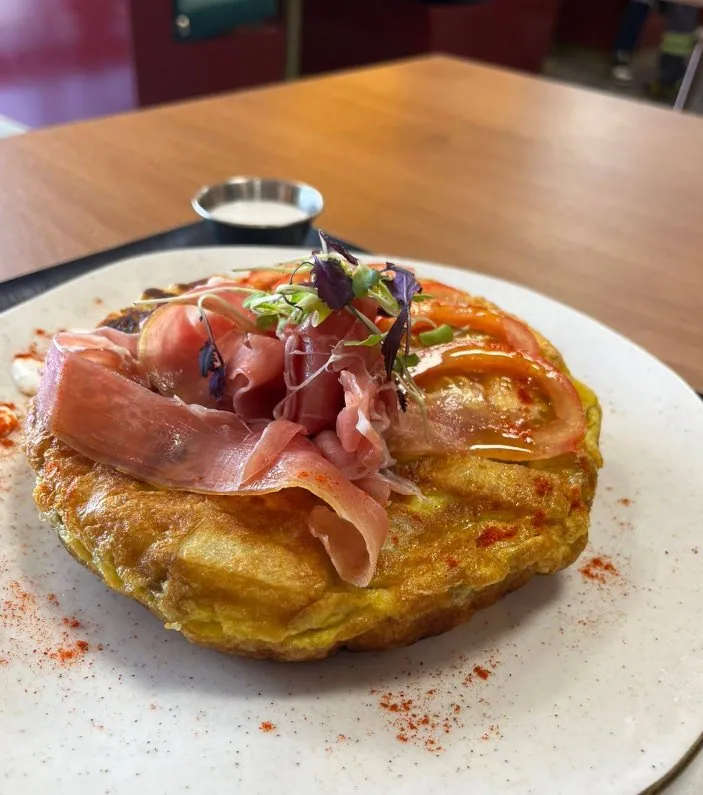 Plato de tortilla con jamón y vegetales