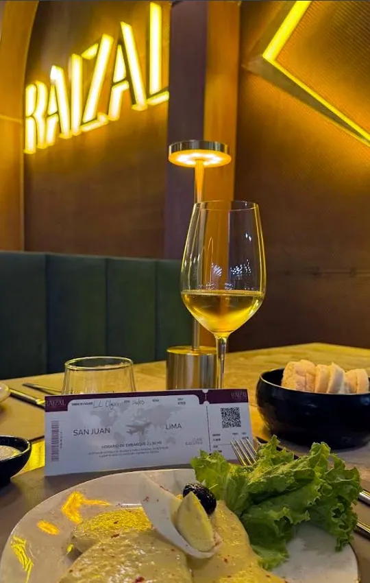 Una mesa de Raizal con vino y platos de la casa